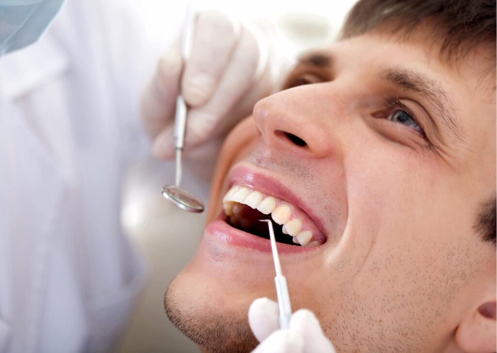 Dentist examining a patient's tooth to determine whether a dental filling or a dental crown is the best treatment option.
