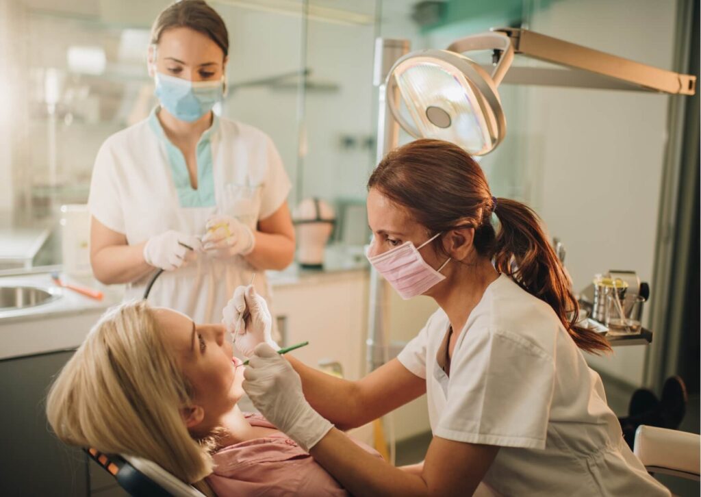 Dentist performing an examination to determine whether a root canal or tooth extraction is the most appropriate treatment for a damaged tooth.